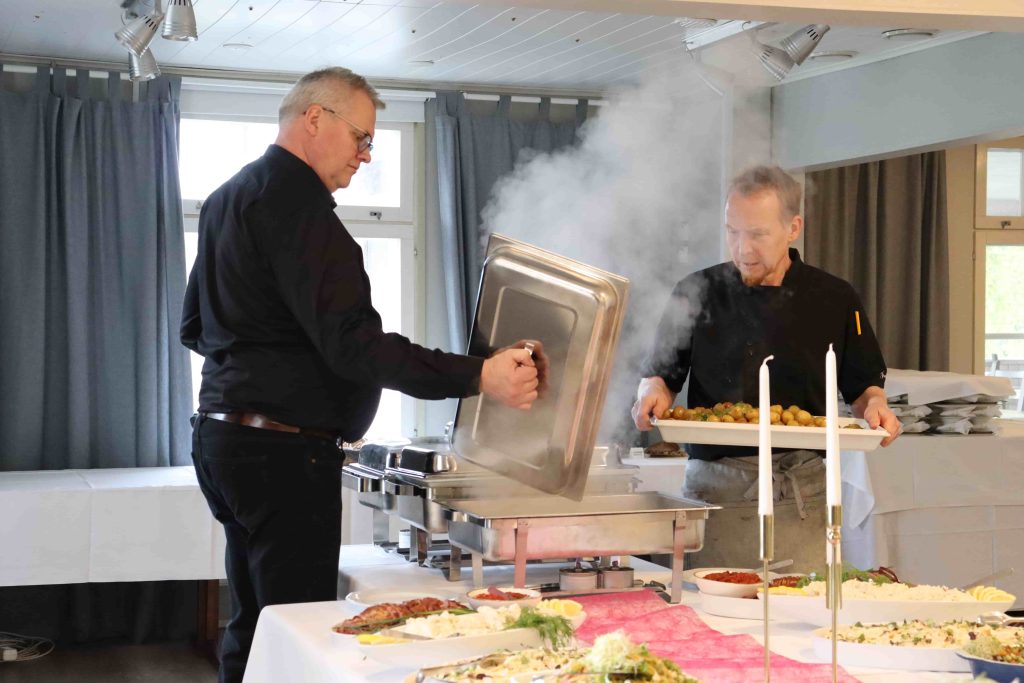 two men placing food on table