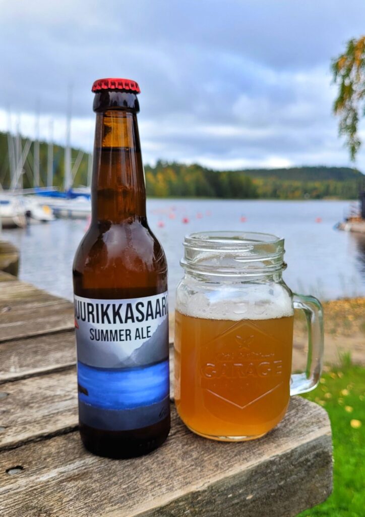 Olutta lasissa järven rannalla
